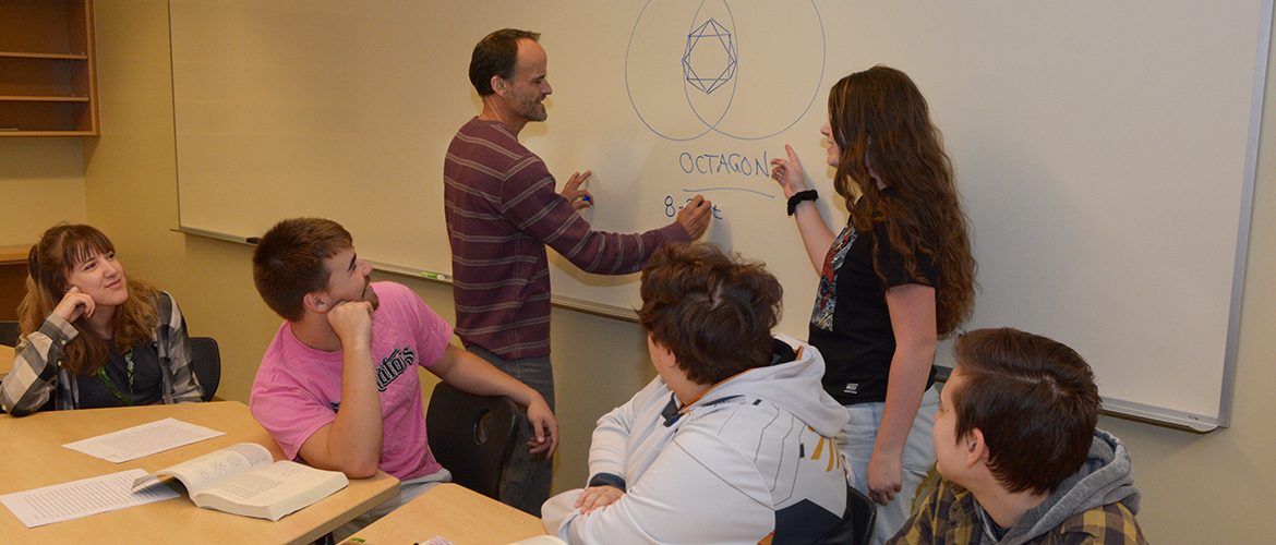 Professor working with students in a math class