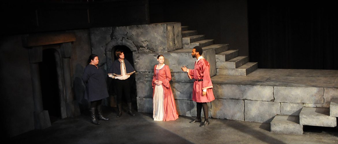 Four students acting on stage during theatre rehearsal