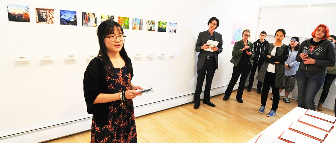 Student presenting her art work in UMF Art Gallery