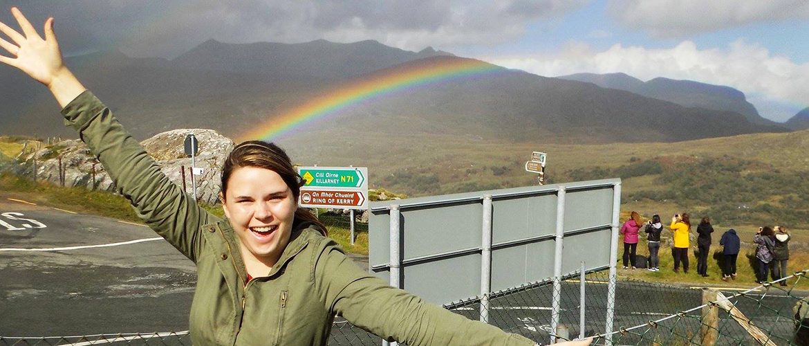 Student studying abroad in Ireland posing with a rainbow
