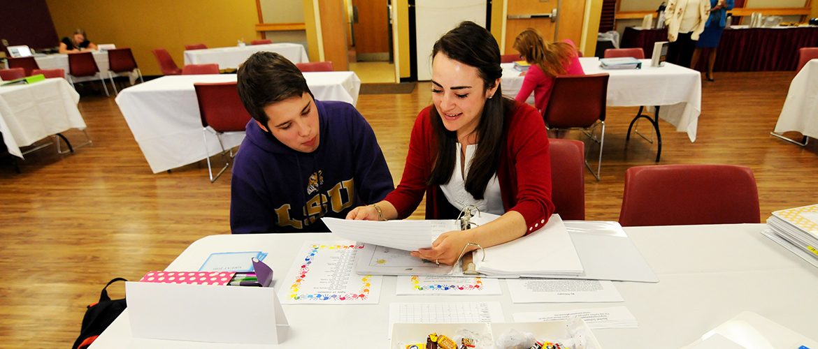 Two students presenting student teacher portfolios in North Dining Hall