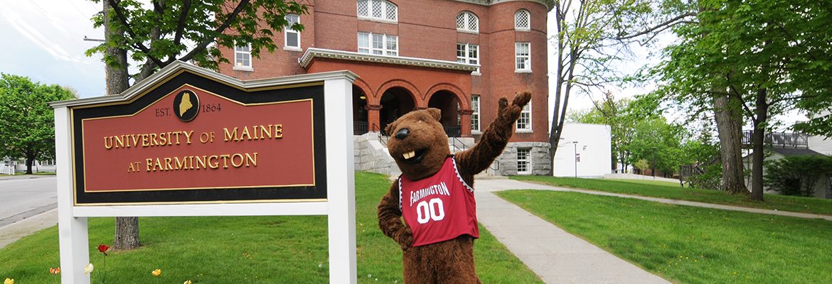 UMF Chompers beaver mascot standing in front of Merrill Hall