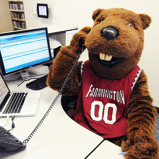 Image of the UMF mascot, Chompers the beaver, answering the phone