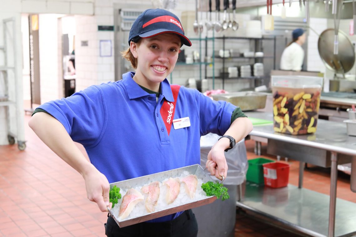 AJ Saulnier displays a tray of locally sourced red fish in UMF's South Dining Hall