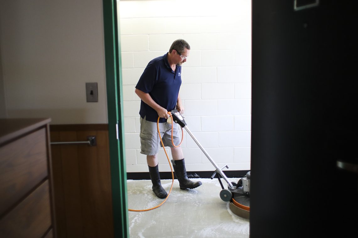 Dan Pease gives the third-floor hallway of Dakin a "deep scrubbing."