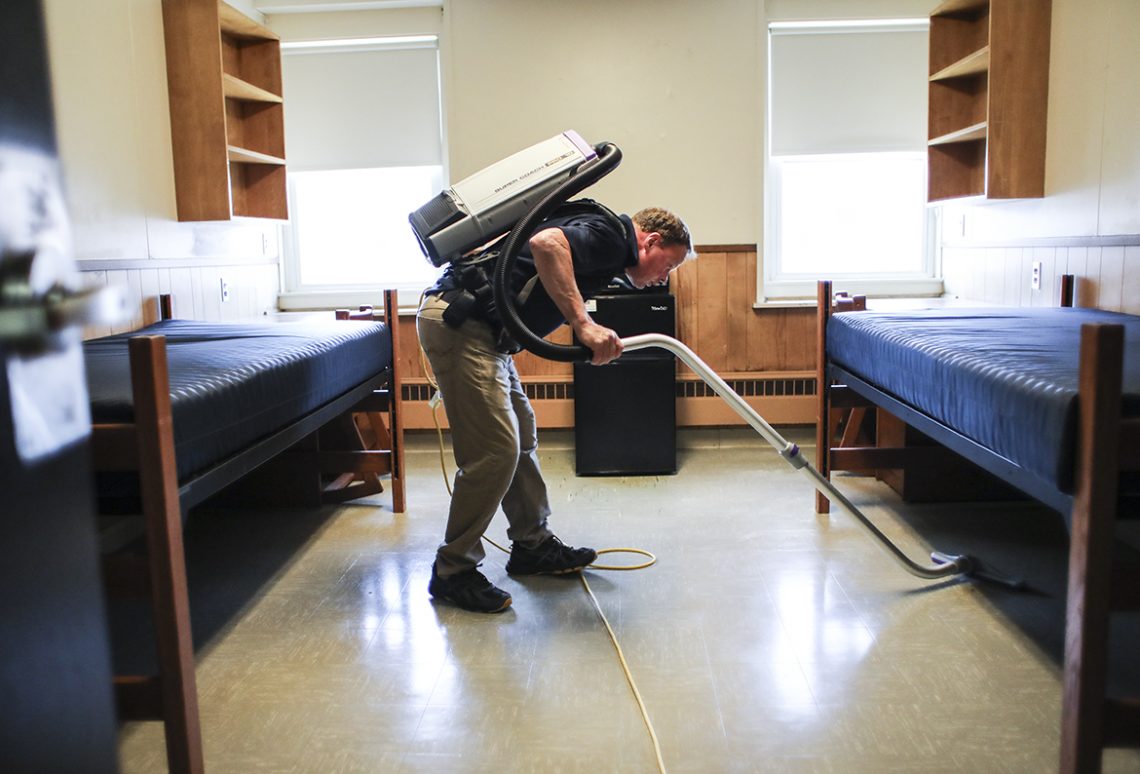 UMF custodian Tim Burnell vacuums a Dakin Hall double in preparation for 2019 move-in day. 