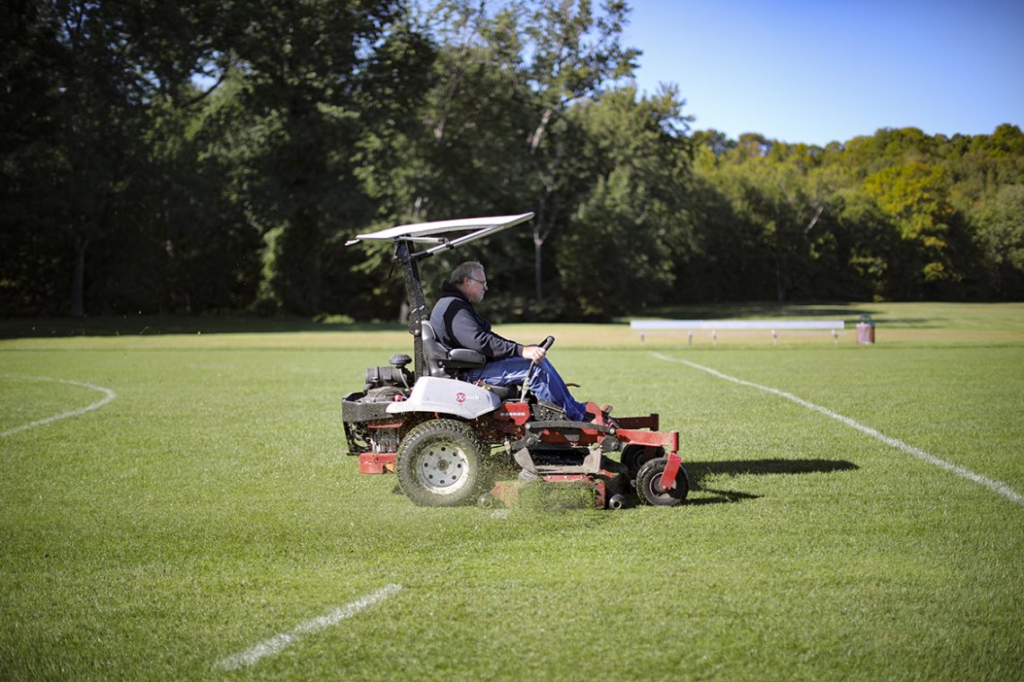 Mark Tyler helms a commercial-grade ExMark mower on the UMF Field Hockey pitch. 