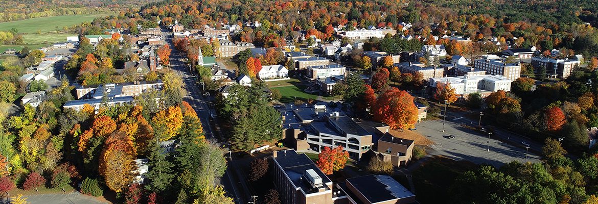 Aerial view of campus buildings, trees, and mountains