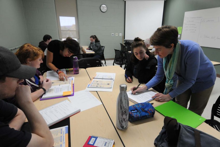 UMF Assistant Professor of French Olivia Donaldson (standing far right) and her teaching assistant work one-on-one with students