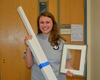 Vanessa Berry, UMF AmeriCorps energy efficiency coordinator, holds miniature sample window insert and pre-cut pieces for window insert build on UMF campus Saturday, Jan. 27 and Monday, Jan. 29