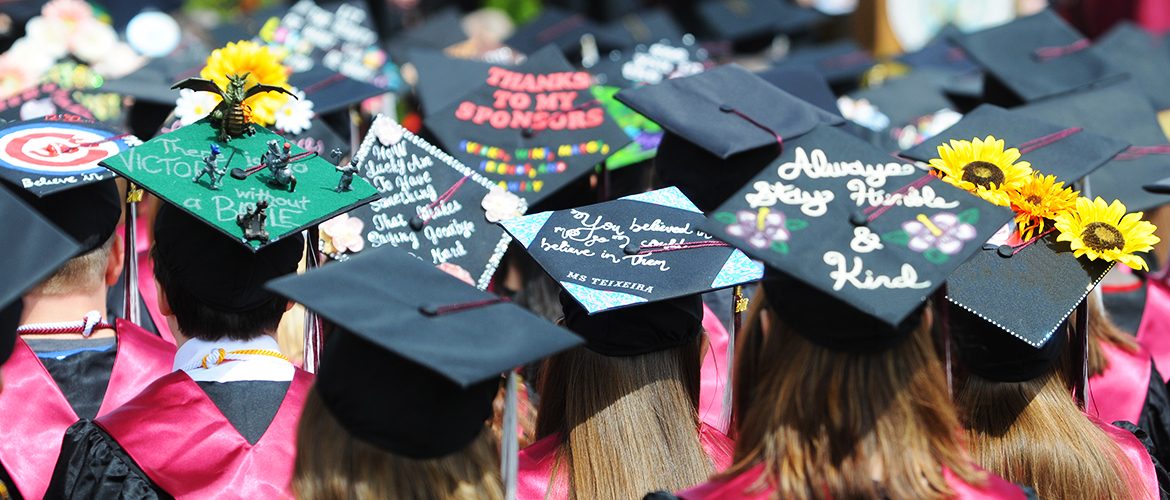 Students' decorated mortarboards at commencement