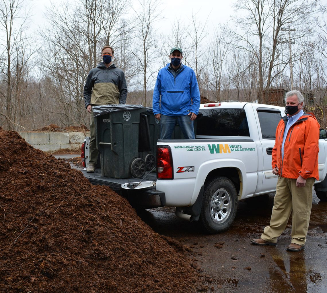 Luke Kellett and Mark Pires, former and current UMF sustainability coordinators, and Jeff McGown, a senior district manager with Waste Management, bring donated truck to site of UMF compost initiative.