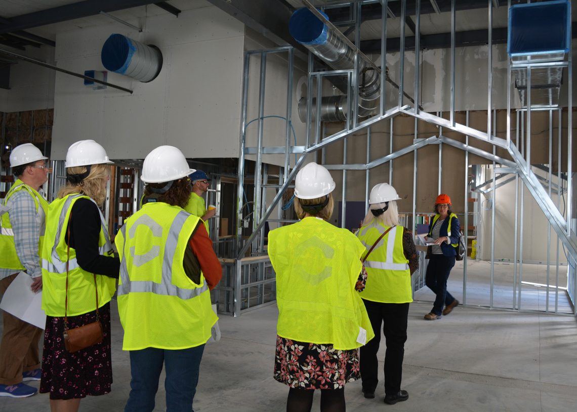 (Far right) Robin Tannenbaum, lead architect with CHA Consulting, Inc., shows members of the building committee the planned gambrel roof architectural play space in the new Sweatt-Winter Center under construction.
